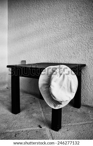 Floppy summer hat hanging off the edge of a coffee table in black and white