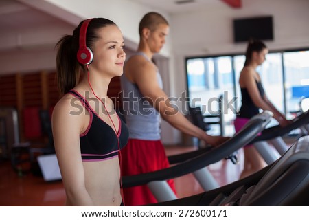 Fitness running people. Sports people running on the treadmill at the gym. Athletes wearing sportswear and running in the gym a rear.