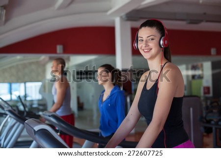 Fitness running people. Sports people running on the treadmill at the gym. Athletes wearing sportswear and running in the gym a rear.