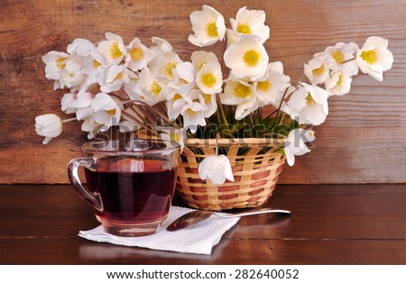 Still-life with a bouquet of white flowers and a cup of tea