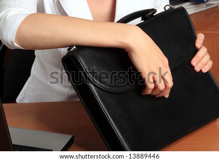 The woman at office holds in hands a black portfolio