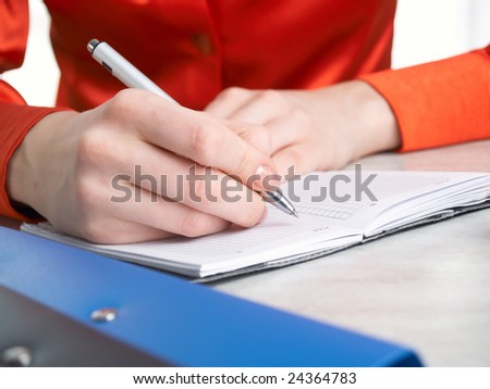 Hands of the girl write in portfolio