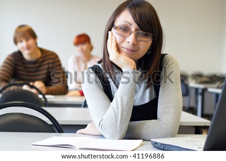 The student in glasses works on notebook
