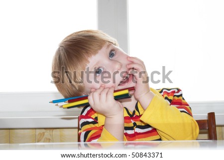Portrait of the little boy with pencils in a hand