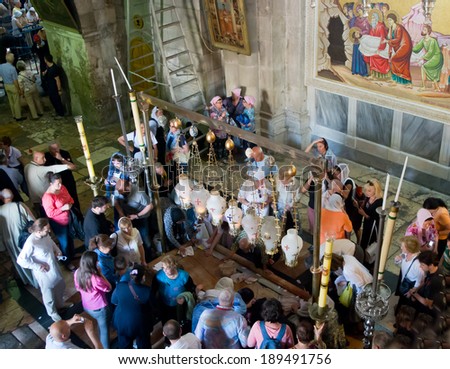 JERUSALEM, ISRAEL - APRIL 21, 2014 : Pilgrims round  Stone of Agony at the enter to Holy Sepulche Church in Jerusalem during  Easter Sunday on April 21, 2014. This place is known as Golgotha Altar.
