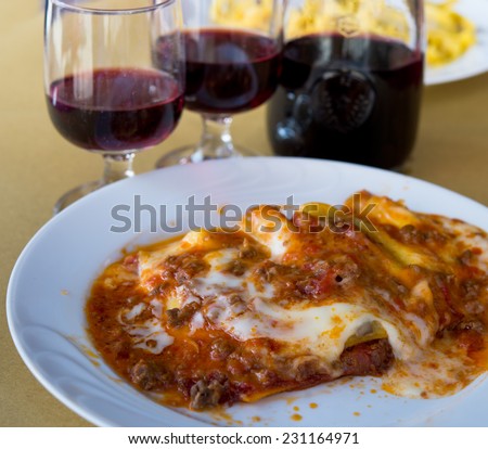 Lasagna  and home red wine in Tuscany restaurant.