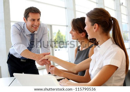 Salesman shaking hands to clients