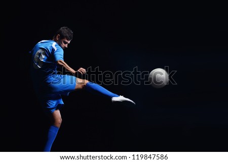 soccer player doing kick with ball on football stadium  field  isolated on black background