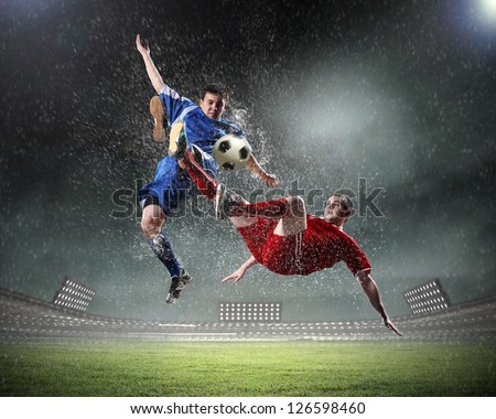 dois jogadores de futebol no salto para bater a bola no estádio