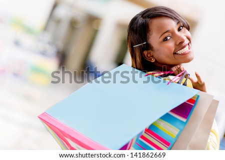 Happy female shopper with shopping bags and smiling