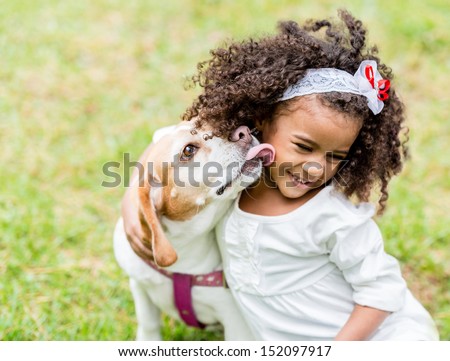 Happy girl with a dog licking her face 