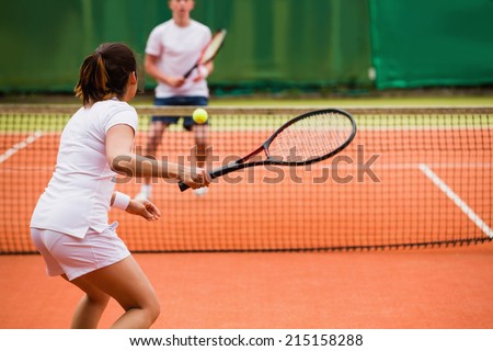 Tennis players playing a match on the court on a sunny day