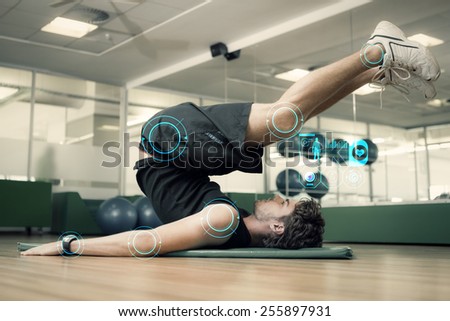 Fit man doing pilates in fitness studio against fitness interface