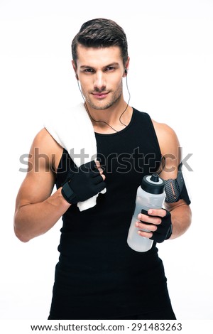 Handsome fitness man holding towel and bottle with water isolated on a white background. Looking at camera