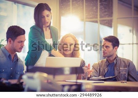 Group of young colleagues using laptop at office