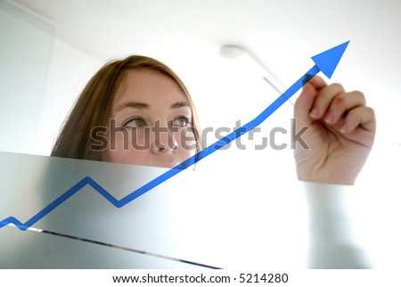 business woman drawing a graph on a glass window in an office - focus is on graph