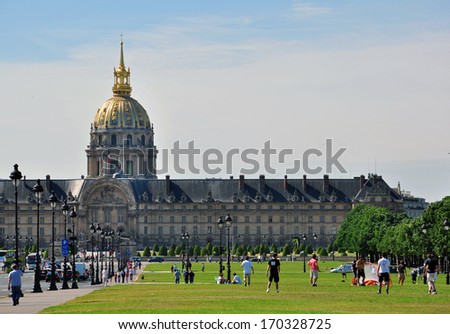 PARIS, FRANCE - MAY 7: Men playing football on the grass field near the Invalides building in Paris on May 7, 2011. Paris is the most famous and touristic city in Europe.