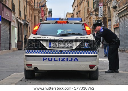 VALLETTA, MALTA - FEBRUARY 28: Car of Malta police department and constable on the street of Valletta on february 28, 2014. Valletta is a capital and the largest city of Malta.