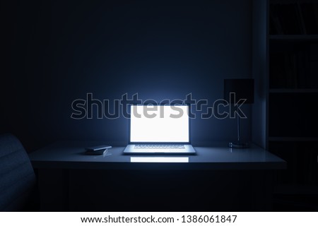 Room illuminated by a computer screen at night, no people. Empty workplace lit by a laptop display in the darkness, late work, overtime concept ストックフォト © 