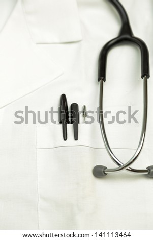 Doctor scrub with stethoscope, thermometer and pens in the pocket.