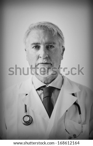 Portrait of a senior doctor. Vintage look with black & white and artistic grain.