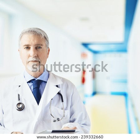 Doctor in the hospital hallway with tablet