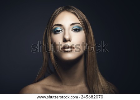 Beauty portrait of young woman against blue background