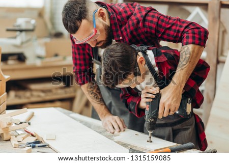 Similar – Image, Stock Photo Male woodworker teaching son in workshop