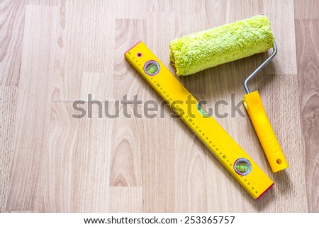 paint roller and building level on the floor