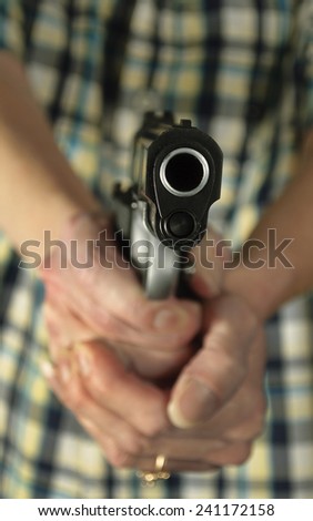 Woman tightly grips her handgun