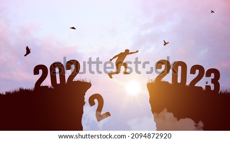 Welcome Merry Christmas and Happy New Year in 2023. Black silhouette man jumping from 2022 cliff to 2023 cliff with cloudy sky and sunlight. Vector illustration.