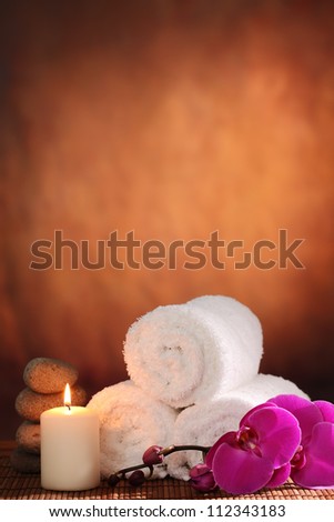 Spa still life with towel,aromatic candle and orchid flower.
