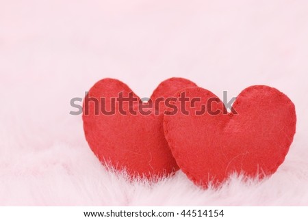 couple of red hearts on pink feather