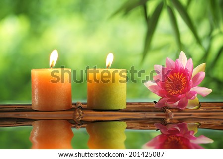 Spa still life with burning candles and water lily.