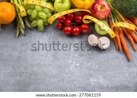 Diet weight loss breakfast concept with tape measure, organic vegetables and fruits.