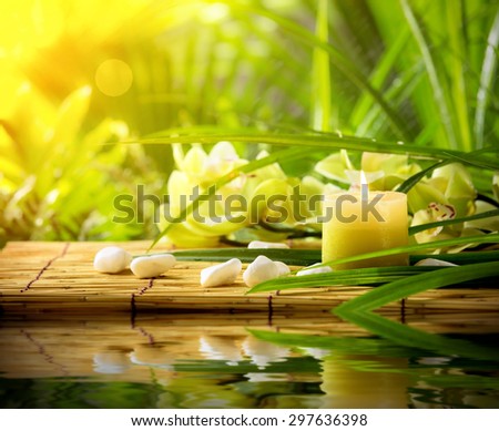 Spa still life with candle,pebble stones and orchid on bamboo mat