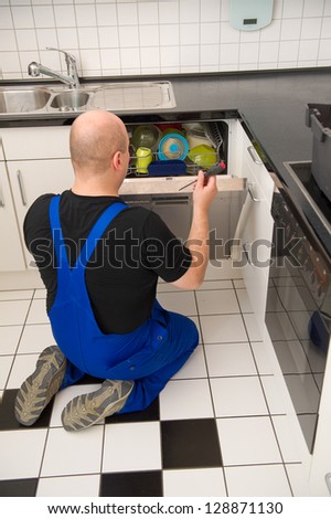 Technician repairs a dishwasher