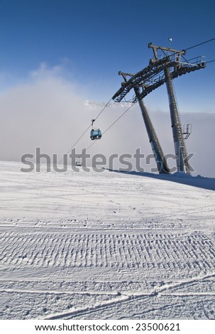 Groomed snow and ski lift with gondola