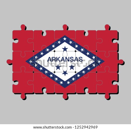 Jigsaw puzzle of Arkansas flag in a field of red and white diamond, bordered by blue and the word 'Arkansas' and stars. The states of America, Concept of Fulfillment or perfection.