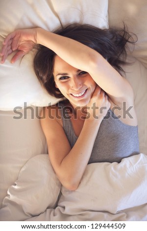 Beautiful relaxed woman too lazy to get up out of her bed