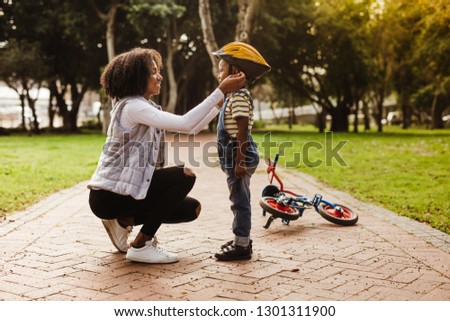 Similar – Image, Stock Photo Mother putting bicycle helmet on her son