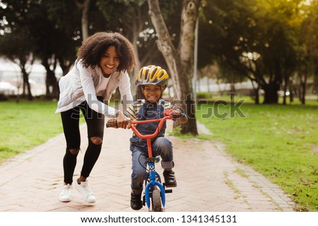 Similar – Image, Stock Photo Smiling black woman riding electric scooter on asphalt road