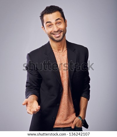 Gesturing cool guy in a studio with one hand in his pocket