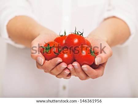 Female's both hands holding fresh tomatoes