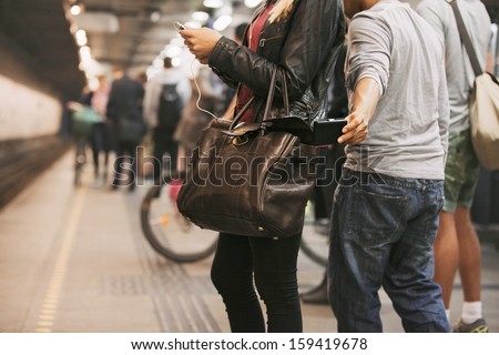 Thief stealing wallet from purse of a woman using mobile phone at the subway station. Pickpocketing at subway station Foto stock © 