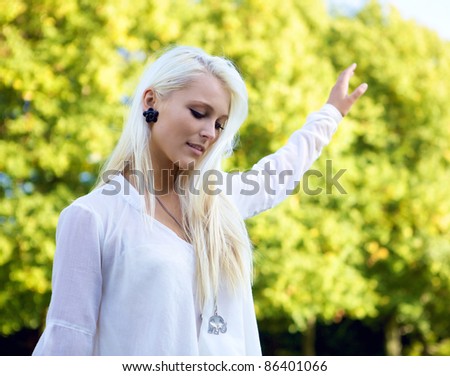Young casual woman balancing in a green park.