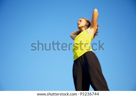 Low angle view of a woman traceur stretching and warming up her muscles before participating in parkour