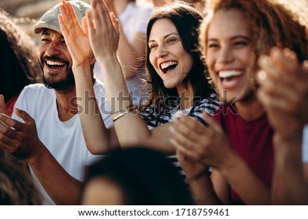 Group of fans watching a sports event in the stands of a stadium. Group of men and women spectators cheering for their team victory. Stock foto © 