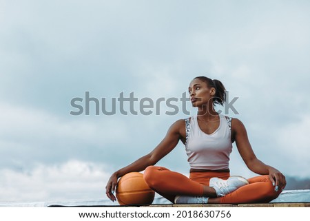 Image, Stock Photo Tired sportswoman with basketball ball resting on court