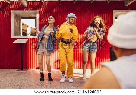 Following fun social media trends. Group of generation z friends doing trendy dance moves in front of a camera phone. Vibrant young people creating content for their social media vlog. Stok fotoğraf © 